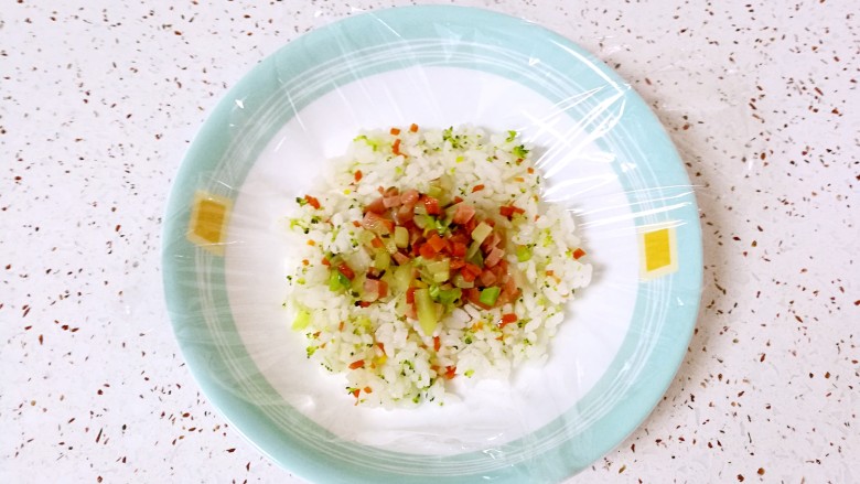 彩蔬饭团,舀一勺炒好的蔬菜丁放在米饭上。