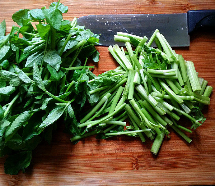 蒜香野水芹,放至案板上切寸段，且将菜茎、菜叶分开切备用