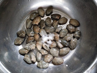 辣炒花蛤,将花蛤放入盆中用淡盐水浸泡吐去泥沙，然后再用清水冲洗干净