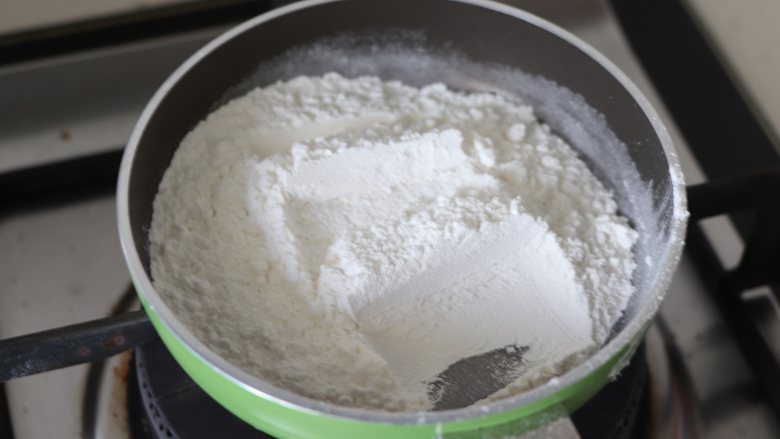 白玉棒棒糖蛋糕，萌系美食,取少量的糯米粉，炒制到稍微发黄， 作为一会要用到的手粉。