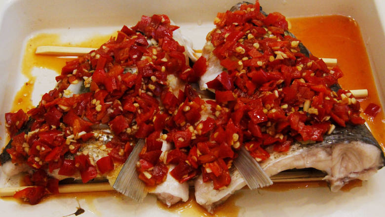 湘菜剁椒鱼头 新手家常菜,辣椒酱加入十克的生抽及切碎的一瓣蒜蓉拌均后，均匀的铺在鱼头上