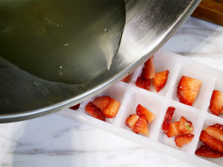 美丽甜品水晶草莓冻,将吉利丁片用清水泡软，然后放到糖水小锅中融化吉利丁片，最后再匀将吉利丁水倒入模具中；