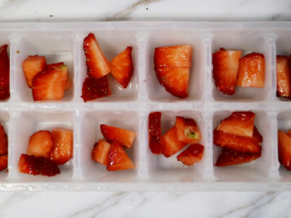 美丽甜品水晶草莓冻,将草莓横切成小块，铺在模具的底部，再将草莓切成丁，铺在草莓片上面。