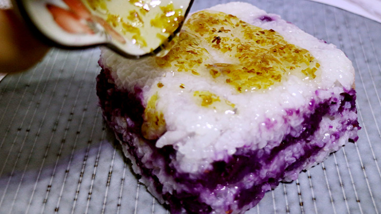 甜糯紫薯糯米糕,倒扣盒子，取出凉糕，再倒上茉莉花蜜均匀的抹在糯米上面，用刀切成厚块这样就可以吃了。