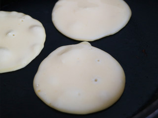 营养丰富的健康早餐之鸡蛋松饼,平底锅烧热后,用小勺子挖起蛋糊放入锅中,用小火煎至底部定型。一面定型后,用用铲子轻轻翻面煎。