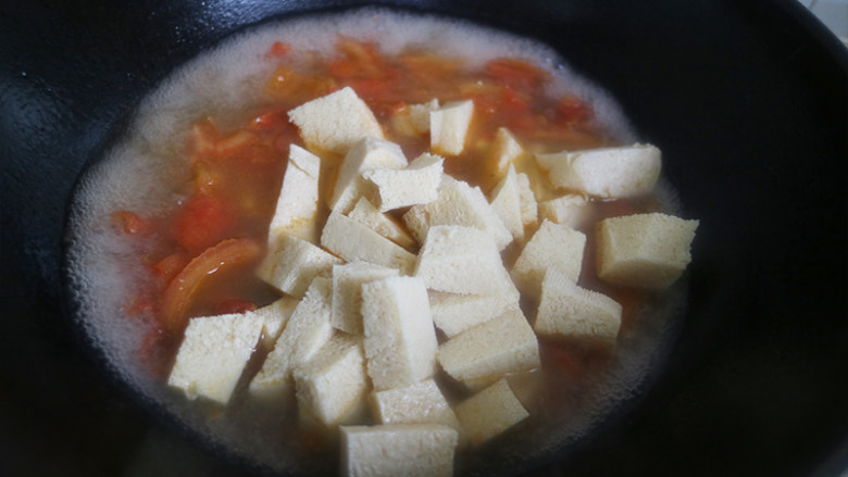 鲜美爽滑的龙利鱼番茄豆腐汤,锅中沸水烧开后，加入豆腐块和龙利鱼块，继续煮。