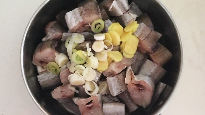 烤香辣鳕鱼,把鳕鱼放入盆中，加入葱花和姜片