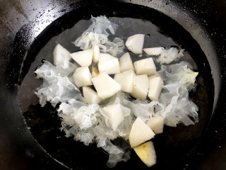 冰糖银耳炖梨,将梨块放到银耳锅中继续煮熟。
