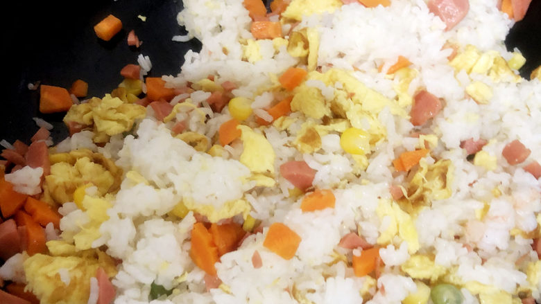 家常蛋包饭,将隔夜米饭倒入鸡蛋液中搅拌均匀，确保每一粒米饭都沾上搅拌加火腿。