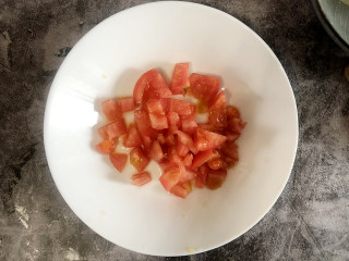 番茄炒菜花,将番茄切成小块，装盘备用。
