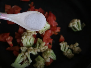 番茄炒菜花,调入白糖、适量的盐，继续翻炒均匀。