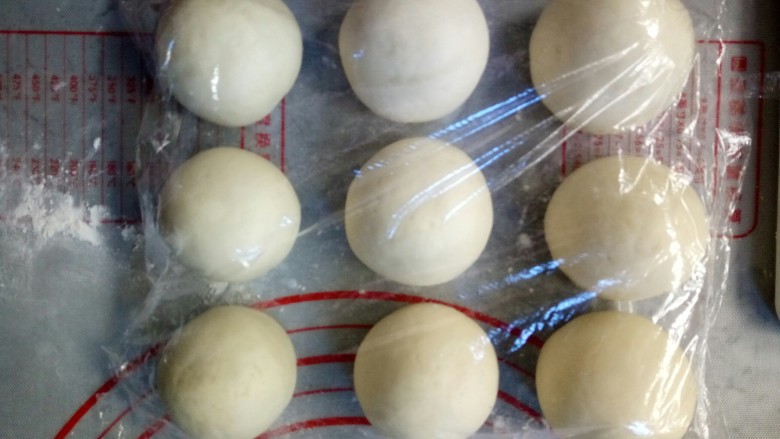 寿桃豆沙包,剩下的白色面团揉成条状，然后切割为9个大小相同的小面团，连绿色面团一起用保鲜膜覆盖，防止表皮吹干。