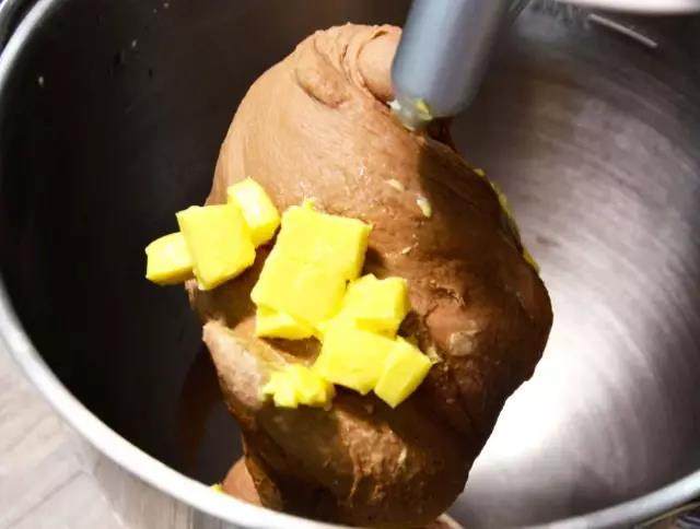 可可麻薯软欧包,面团揉至较光滑状态，加入软化的黄油低档揉至黄油吸收。