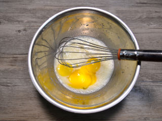 肉松小蛋糕,将蛋黄部分的牛奶、玉米油和细糖混合搅拌至糖完全融化后加入蛋黄，搅拌均匀。