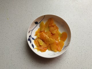 香橙海绵纸杯蛋糕,然后用刮刀刮下橙皮，注意只刮表面不要刮到白色部分。