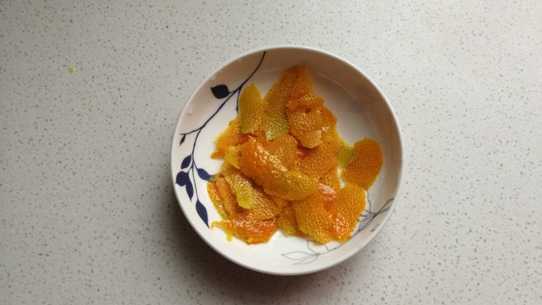香橙海绵纸杯蛋糕,然后用刮刀刮下橙皮，注意只刮表面不要刮到白色部分。