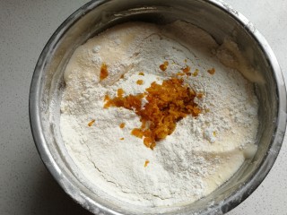香橙海绵纸杯蛋糕,然后筛入低筋面粉，再加入橙皮屑翻拌均匀。
