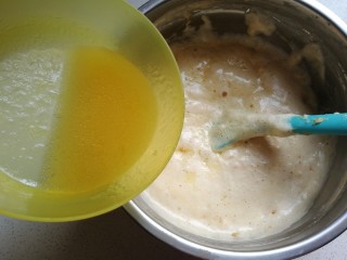 香橙海绵纸杯蛋糕,蛋糊拌好后，再把橙汁和玉米油混合液沿着刮刀淋在蛋糊表面上，再翻拌均匀。