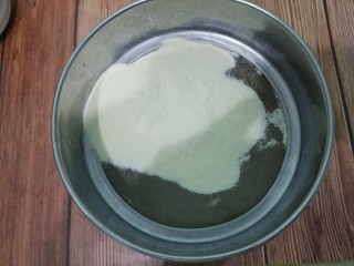 蛋黄溶豆,然后把奶粉筛入碗中。