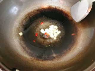 炒花蛤,锅中热油，小辣椒和蒜片炒香。