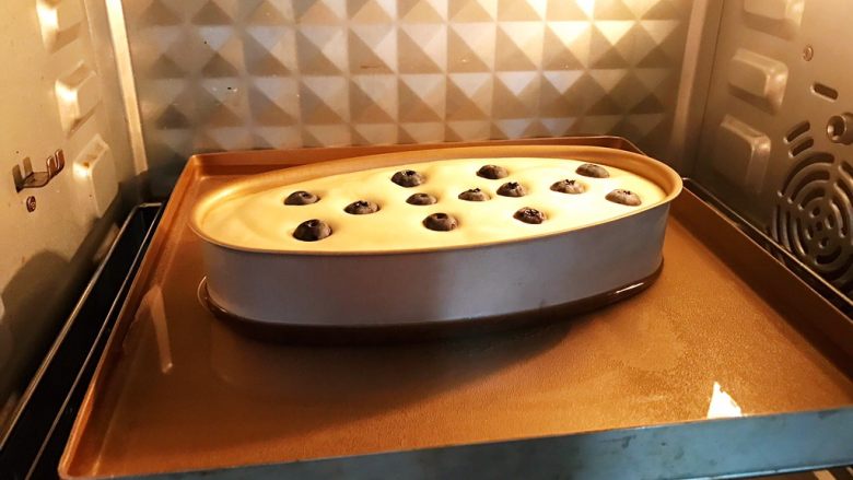 无油蓝莓酸奶蛋糕,放入预热好的烤箱中下层上下火水浴法140度烤烤60分钟