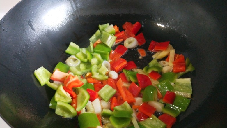 快手正餐 豆皮炒鸡丁,倒入红椒丁，菜椒丁炒均匀。