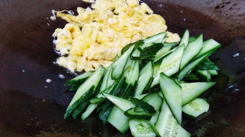 快手正餐 黄瓜炒鸡蛋,鸡蛋炒至如上图后，刨到锅边，倒入黄瓜片翻炒。