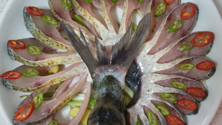 开屏五昌鱼,把腌好的五昌鱼摆入盘内，摆成孔雀开屏的样子，用青鱼椒装饰一下。
