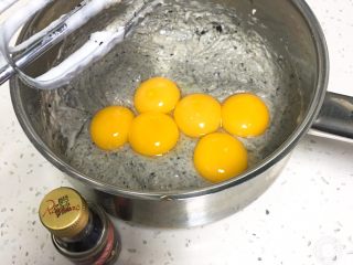 芝麻核桃蛋糕,加入蛋黄和香草精，这次的鸡蛋有一个是双黄鸡蛋。先用打蛋器后用刮刀翻拌。