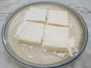 米饭杀手的家常菜~锅塌豆腐,淀粉倒入平盘中，把豆腐两面均匀粘上淀粉。