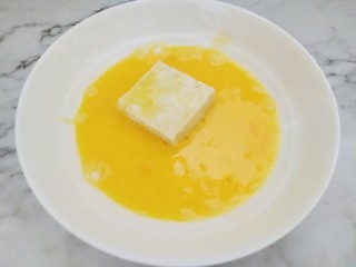 米饭杀手的家常菜~锅塌豆腐,鸡蛋打散装在平盘中，把粘好淀粉的豆腐两面都均匀粘上鸡蛋液。