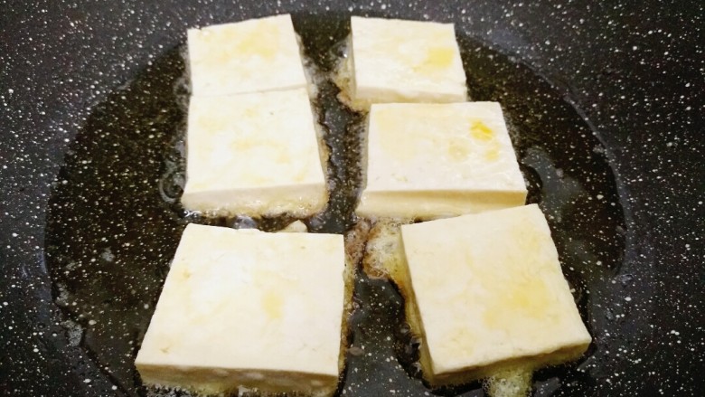 米饭杀手的家常菜~锅塌豆腐,锅内倒入适量油，放入豆腐块，小火慢煎。