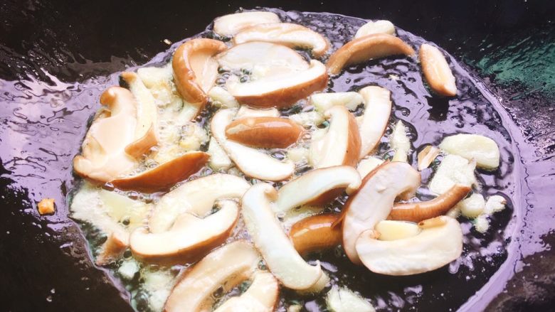 快手正餐 香菇炒油菜,起油锅，热锅凉油，加入蒜头爆香，然后加入香菇，快速翻炒。