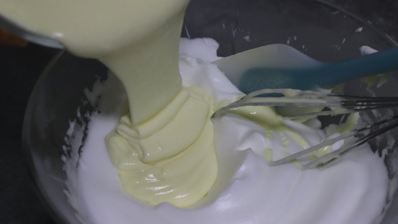 乳酪戚风 细腻轻盈口感好,取一部分蛋白混入到蛋黄糊中，翻拌均匀。