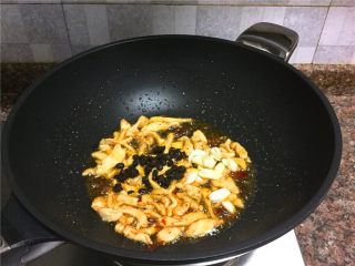 红椒木耳炒鸡丝,放入豆豉和大蒜片翻炒10秒。