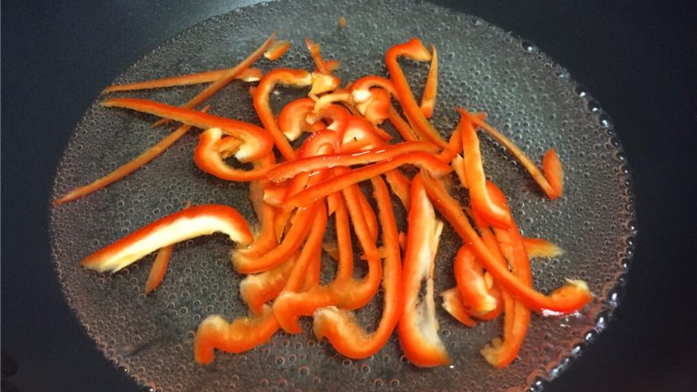 红椒木耳炒鸡丝,烧沸水将红椒焯水1分钟后捞出沥干水份。