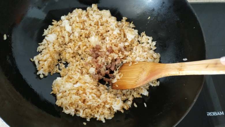 快手早餐 酱油蛋炒饭,第5步，米粒上色之后加入香肠丁，鸡蛋，继续翻炒均匀。