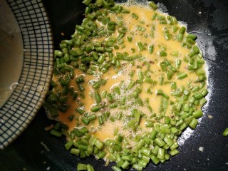 快手正餐 豇豆炒蛋,在鸡蛋中加入10毫升料酒打散，将打散的蛋液均匀淋入锅中炒至变色的豇豆上。