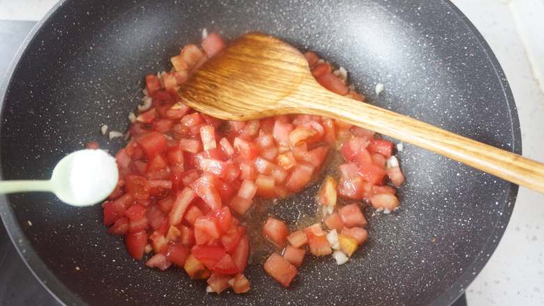 茄汁金针菇,放入西红柿丁，加少许食盐翻炒，现在加盐可以加速西红柿出汤
