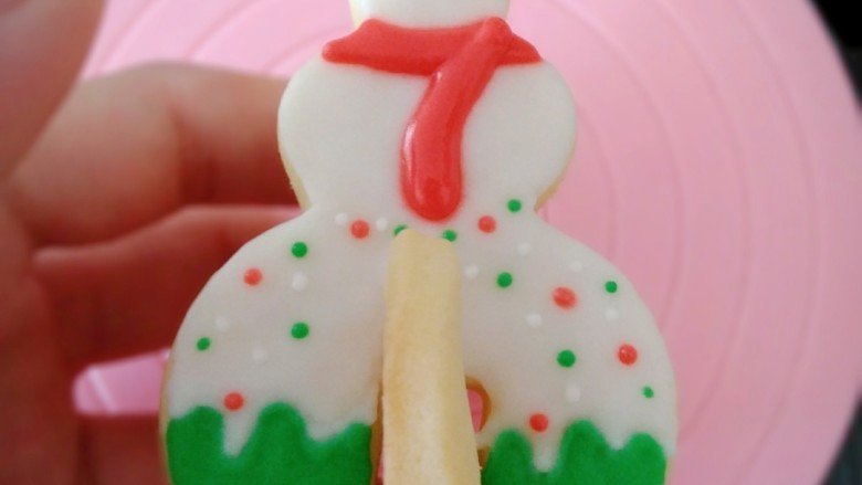 圣诞系列糖霜饼干（超详细）,雪人的部分是除了帽子部分，其他地方用白色糖霜铺面。晾干后用红色糖霜画出帽子和围巾部分，雪人底座部分用绿色填充。