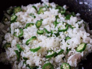 清新营养的秋葵蛋炒饭,把米饭用锅铲打散后、继续用大火翻炒均匀后