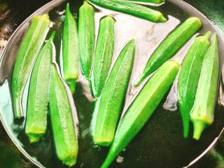 快手正餐 凉拌秋葵,锅放水烧开，放入适量玉米油，把秋葵氽烫约3分钟，颜色变翠绿，捞起来，立即放入冰水里泡凉，以保持其脆绿