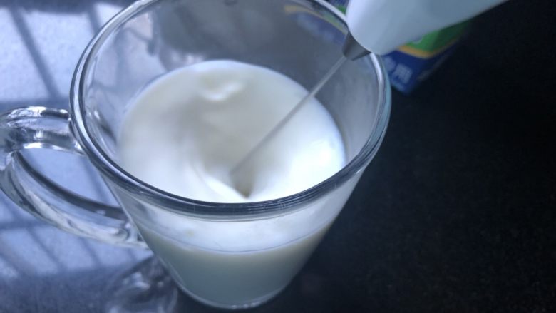 蜜桃乌龙奶茶,取出，耐心的用打奶泡器打出泡，奶泡器不要露出液面。尽量把牛奶打绵密。