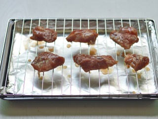 蜜汁叉烧肉,将腌好梅花肉晾在烤网上，烤盘底部铺一层锡纸