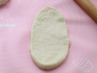 淡奶油老式面包,取一个松弛好的面团，用擀面杖擀成椭圆形