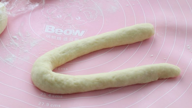 淡奶油老式面包,用手将其从中间向两边揉搓成长条状，两端对折