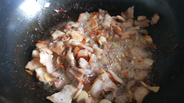 快手正餐 豆角焖面,锅中放入适量油烧热爆香葱姜蒜，放入五花肉炒稍微变黄一点。