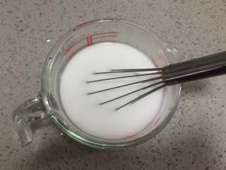 酸辣凉粉,首先我们把125克的豌豆淀粉和200毫升的清水混合，用蛋抽搅拌均匀至完全溶解。

