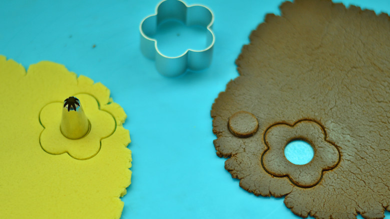 双色花朵饼干,用磨具压出花朵的样子，再用裱花用具压出圆心 