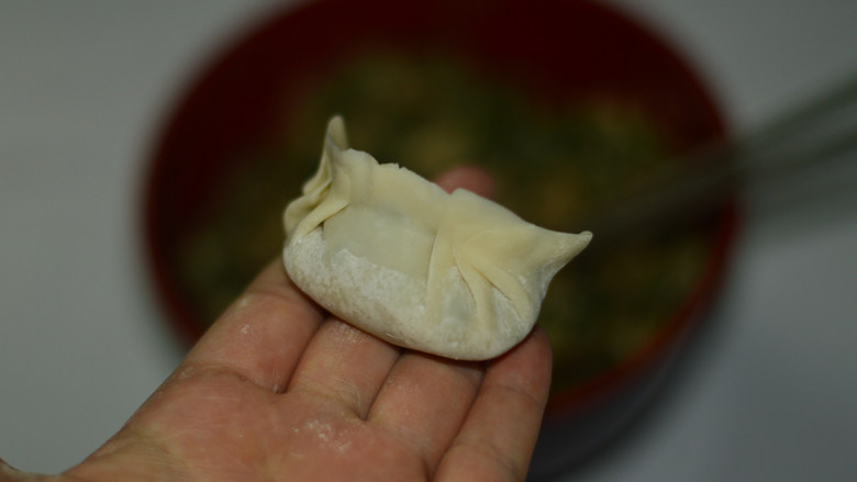 韭菜煎饺,将饺子皮对折，两边的皮捏紧，包成饺子状